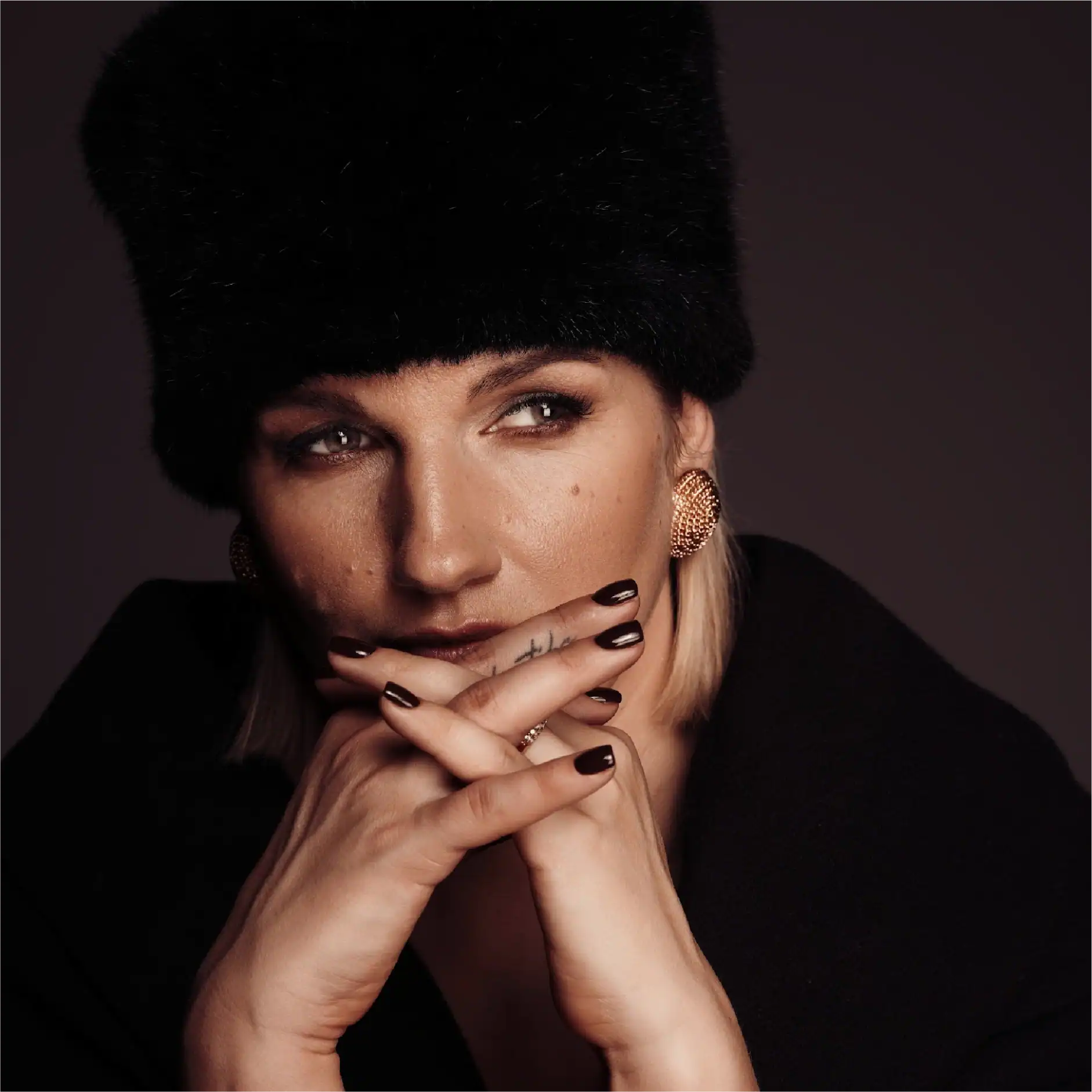 Portrait of Eva Broda wearing a black fur hat and stylish accessories.