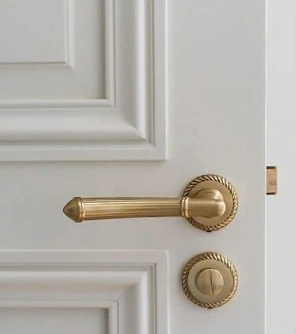 Maniglia e serratura dorate su una porta bianca, elegante elemento di arredamento per la casa.