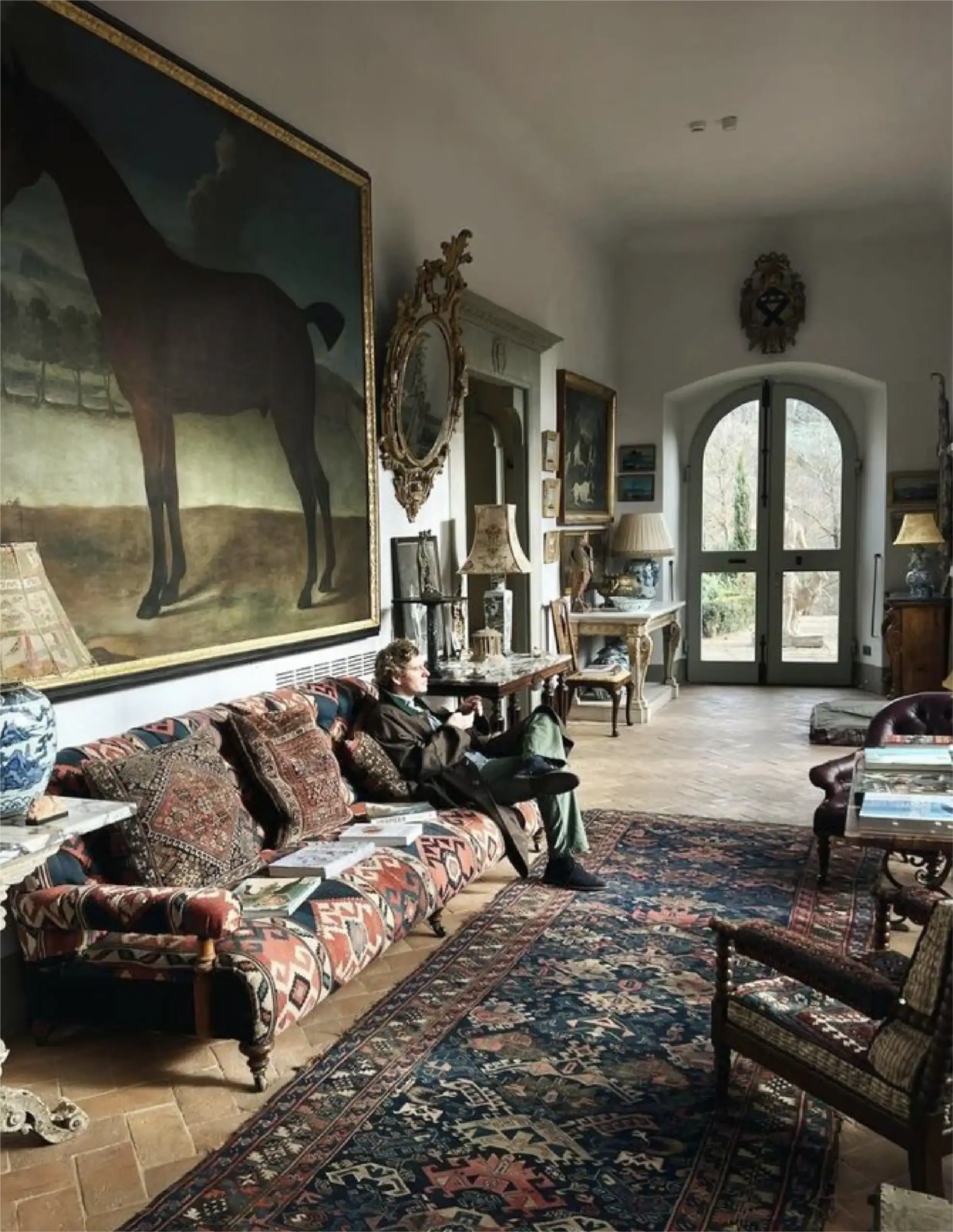Soggiorno spazioso con mobili d'antiquariato, grandi opere d'arte e luce naturale.