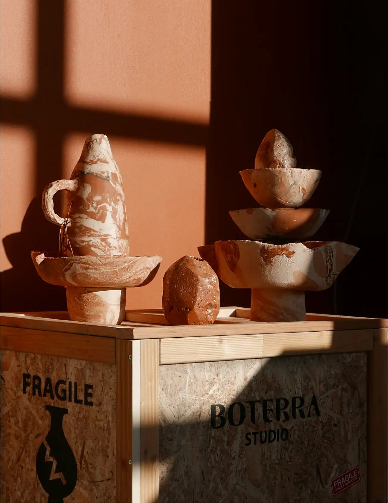 Esposizione di ceramiche da Boterra Studio con luci calde e sculture artistiche.