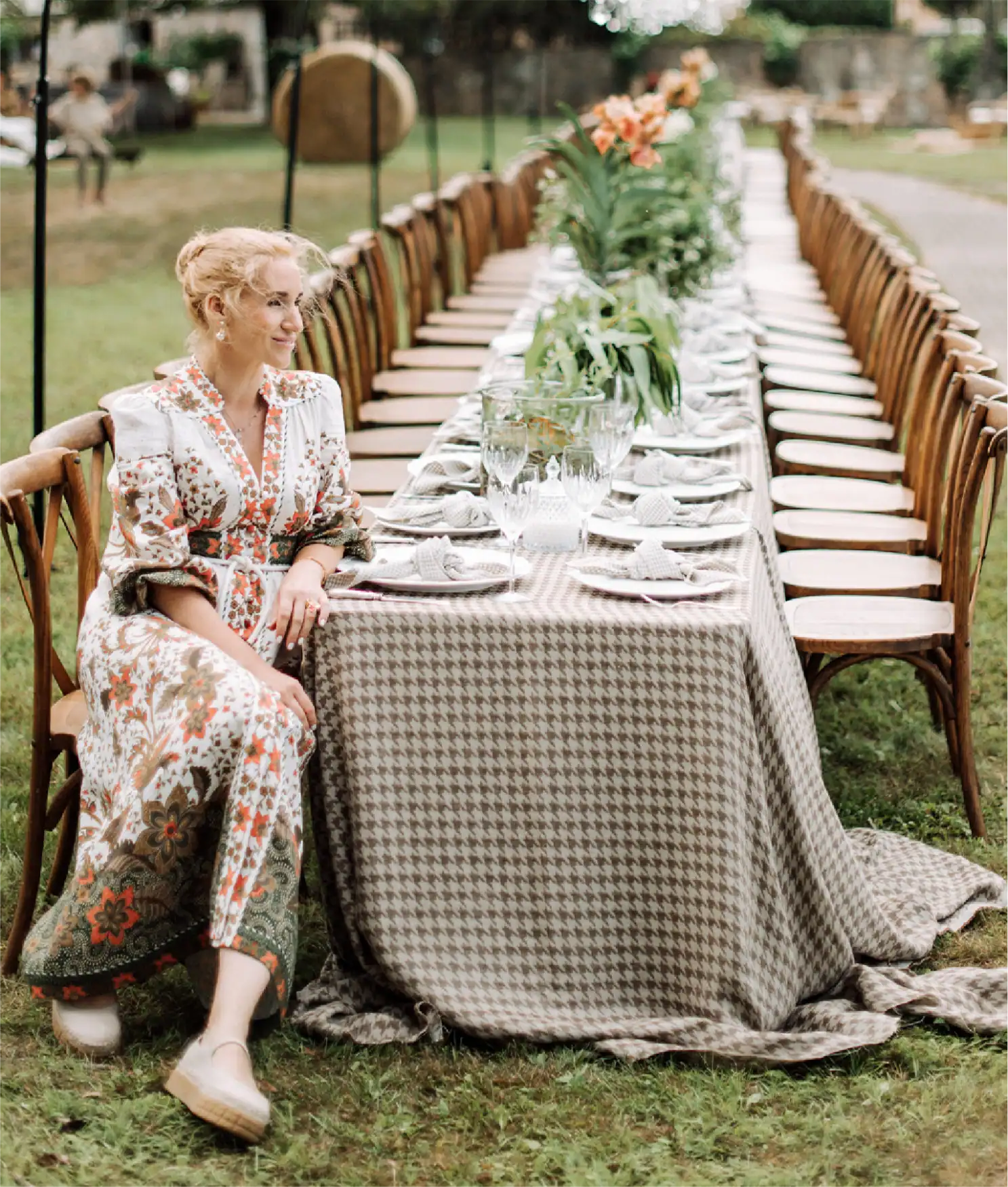 Ricevimento di matrimonio all'aperto in giardino con tavolo lungo e centrotavola floreale.
