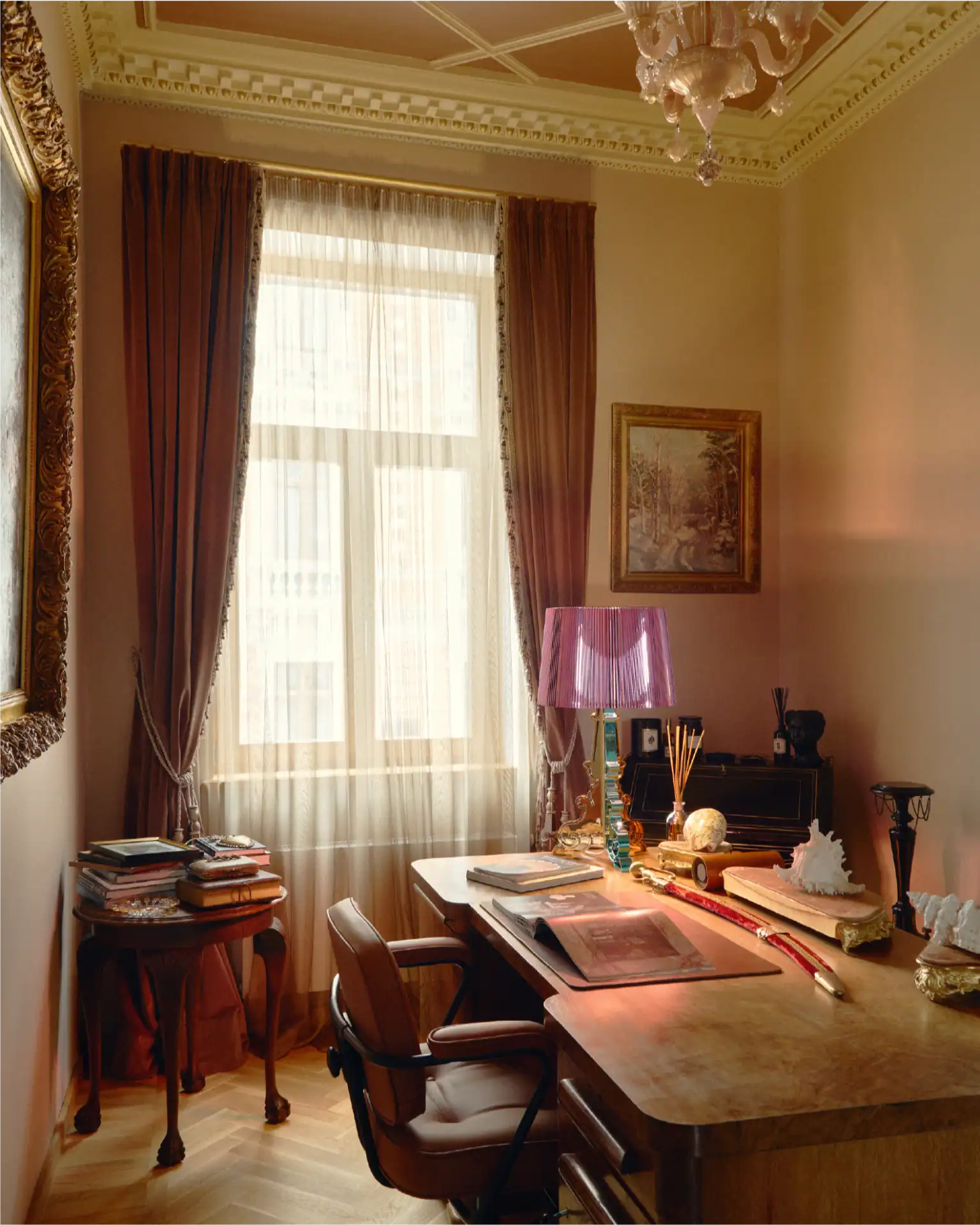 Interno di un home office con mobili classici, un'ampia finestra e accenti decorativi.