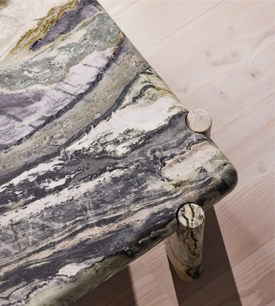 Tavolo in marmo con venature naturali, bordi arrotondati e design moderno.
