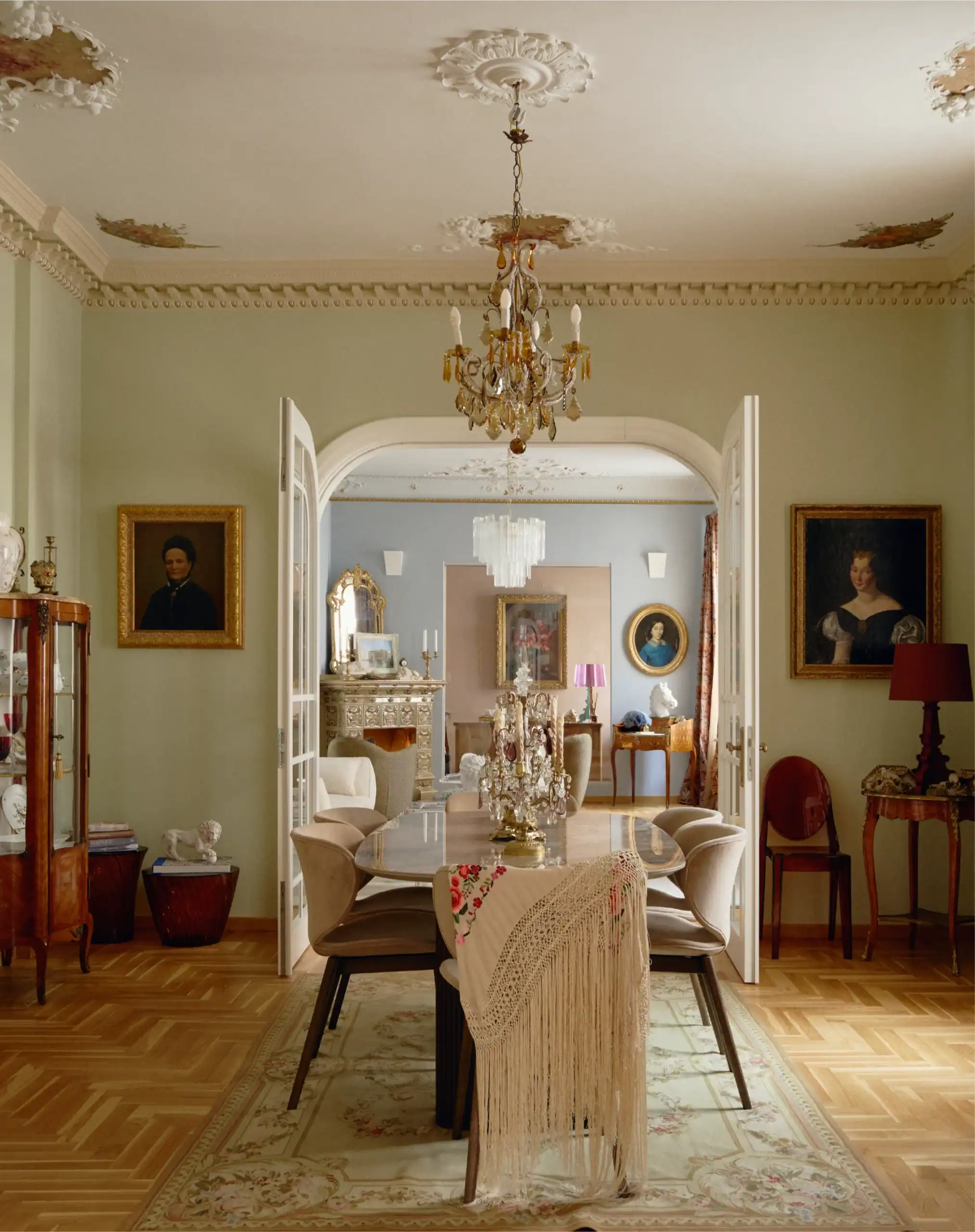 Elegante sala da pranzo vintage con decorazioni classiche, lampadario e mobili antichi.